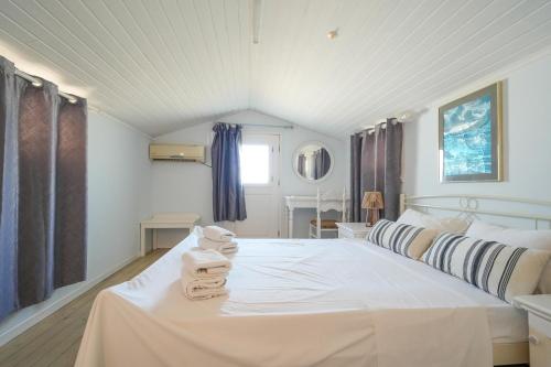a bedroom with a white bed with towels on it at Sofia-Irini in Kalamaki
