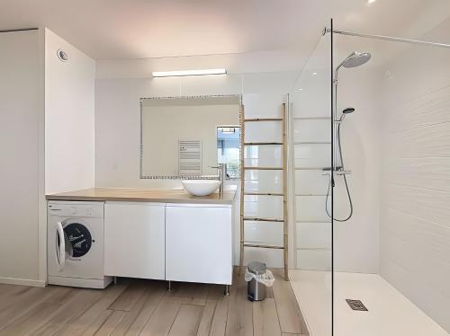 a bathroom with a sink and a washing machine at Gite Leny proche Colmar in Ingersheim