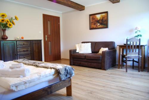a living room with a couch and a chair at Agroturystyka Pod Czaplami in Pieniężno