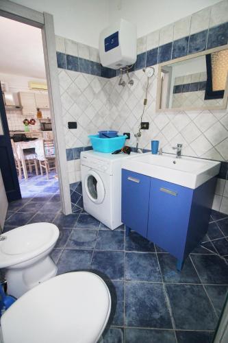 a bathroom with a sink and a washing machine at Appartamento Buggerru Blue Nest in Buggerru