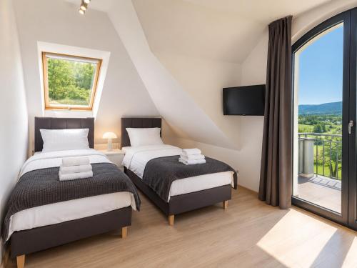 a bedroom with two beds and a large window at Wichrowe Wzgórze dom na wyłączność 5 sypialni Kraków 50 min in Tworkowa