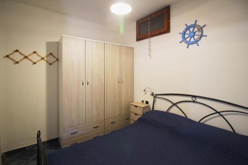 a bedroom with a bed and a large wooden cabinet at Appartamento Buggerru Blue Nest in Buggerru