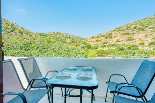 a blue table and chairs on a balcony with mountains at Vergici Apartment 2 in Kómi
