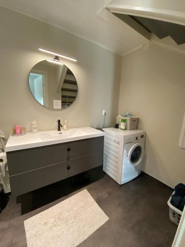 a bathroom with a sink and a washing machine at Apartment in beautiful Stange in Stange