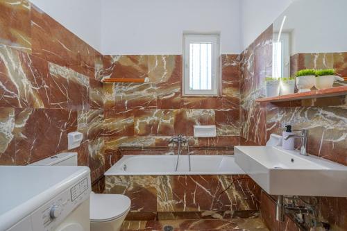 a bathroom with a tub and a sink and a toilet at R&M Ocean View in Dhaskalión