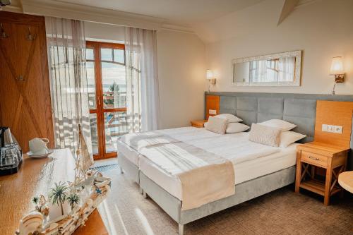 a bedroom with a large bed and a large window at Hotel Kahlberg in Krynica Morska