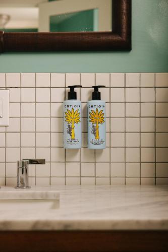 two soap dispensers on the wall of a bathroom at Barlume Beach in Montauk