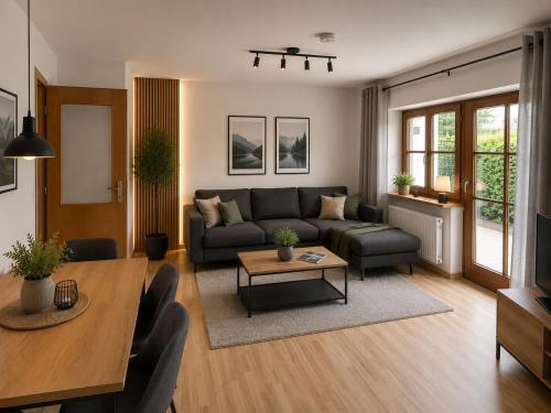 a living room with a couch and a table at Haus Dippel am Kurpark inklusive Chiemgaukarte in Ruhpolding