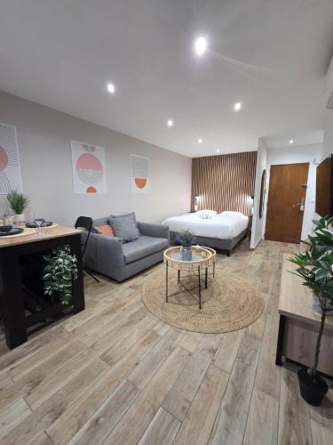 a living room with a couch and a table at Studio cosy devant RER B TGV Massy SNCF in Massy