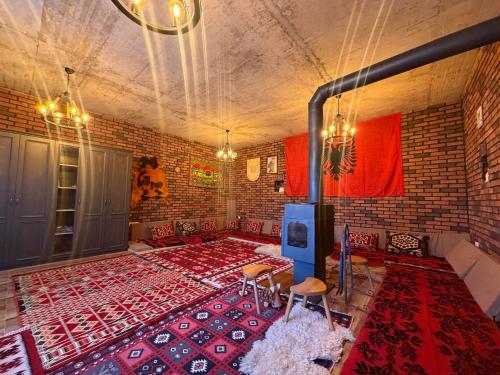 a room with a large red rug on a brick wall at Villa Berisha in Mazgit