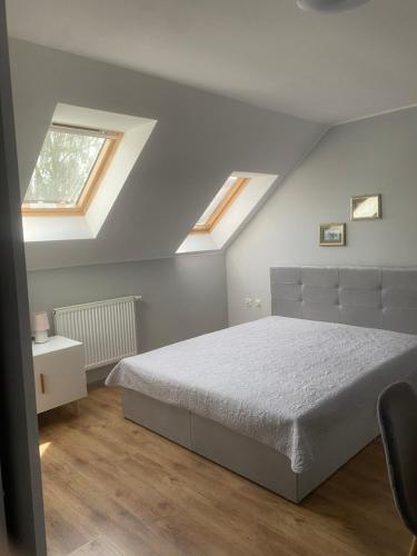 a bedroom with a bed and two skylights at Pokoje u Doroty in Niechorze