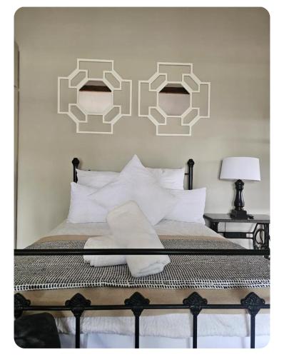 a bedroom with a bed with two mirrors on the wall at StayAtGoethe in Secunda