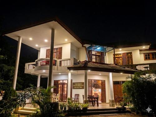 a large white building with a balcony at night at The White Grand Heritage in Balangoda