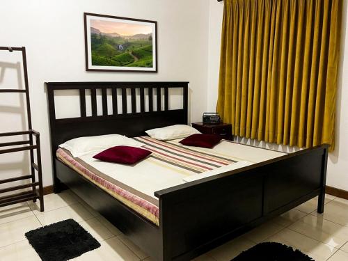 a bedroom with a bed with red pillows on it at The White Grand Heritage in Balangoda