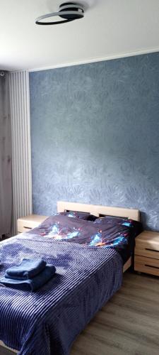ein Schlafzimmer mit einem Bett und einer blauen Wand in der Unterkunft Michael Apartment in Valga