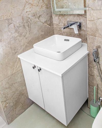 a bathroom with a white sink on a cabinet at Solaris Luxury Residence Osu Pool Gym in Accra