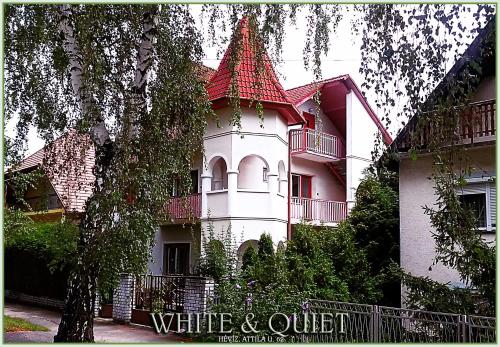 a white and red building with a red roof at White & Quiet Apartment House in Hévíz