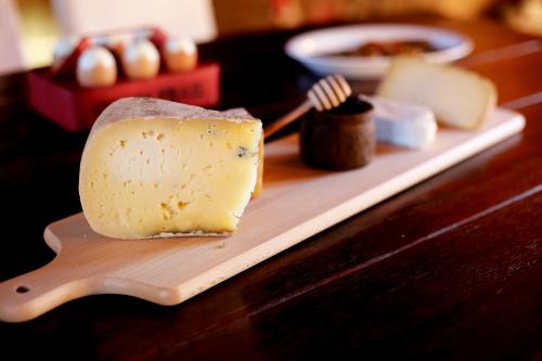 a piece of cheese on a wooden cutting board at Guest House I Vicini di Cesare in Castelnuovo