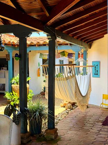an outdoor patio with hammocks hanging from a pergola at Hostel Trip Monkey Barichara in Barichara