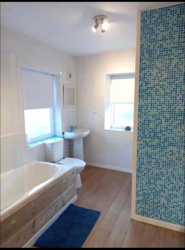 a bathroom with a bath tub and a sink at Anghorfa in Llanberis