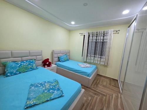 a bedroom with two beds and a shower at N'Gegaj Villa in Shkodër