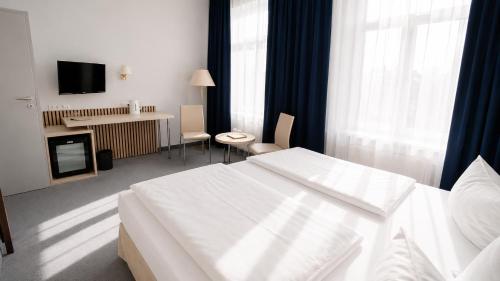 pokój hotelowy z białym łóżkiem i biurkiem w obiekcie Saigon Blue Hotel w Dreźnie