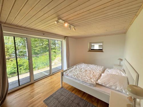 a bedroom with a bed and a large window at Villa Bergsmåla in Eringsboda