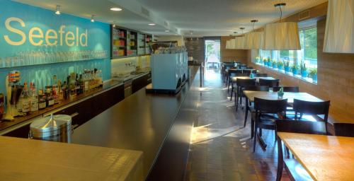 a restaurant with a bar with tables and chairs at Gasthof Seefeld in Hurden