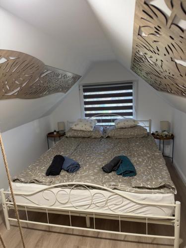 a bedroom with a bed with two hats on it at Harmat Apartman Hajdúnánás in Hajdúnánás