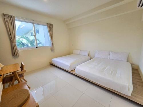 a bedroom with two beds and a window at 日子有光 SHINE Inn Day in Hengchun South Gate