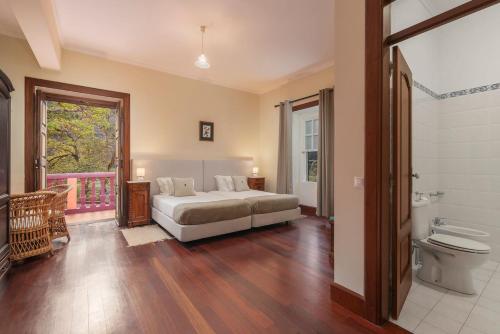 a bedroom with a bed and a bathroom with a toilet at Casa da Fajã Alta in São Jorge
