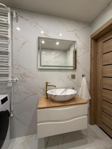 a bathroom with a sink and a mirror at Anuszka Apartament 3 in Gdynia