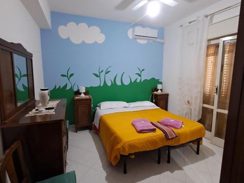 a bedroom with a yellow bed and a green wall at Rosa's House Bed and Breakfast in Santa Margherita di Belice