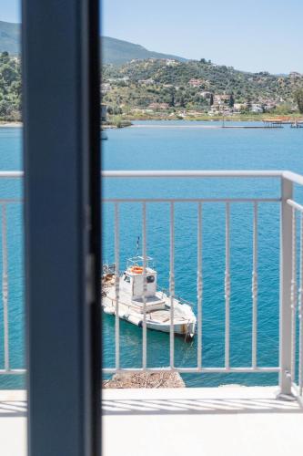 a boat sitting in the water on a balcony at EARTH VILLA Poros in Poros