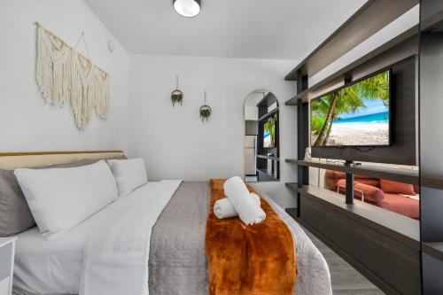 a bedroom with a bed and a tv on a wall at Miami Downtown Bayside Balcony Studio in Miami
