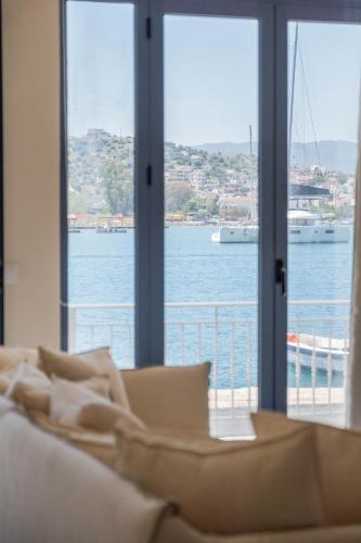 a living room with a couch and a view of the water at EARTH VILLA Poros in Poros