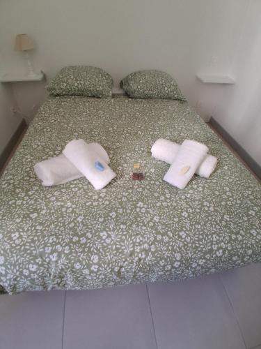 a bed with two towels and two dolls on it at Santoni House in Ghisoni