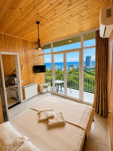 a bedroom with a large bed and a large window at Alis House 3 in Batumi