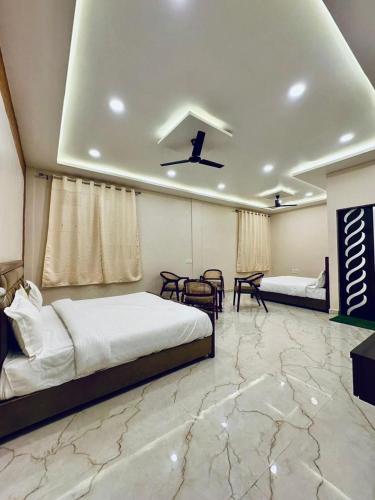 a bedroom with two beds and a table and chairs at Kanha Green in Habībganj