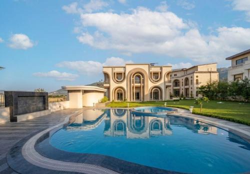 a large house with a swimming pool in front of it at Oryana Resort in Udaipur