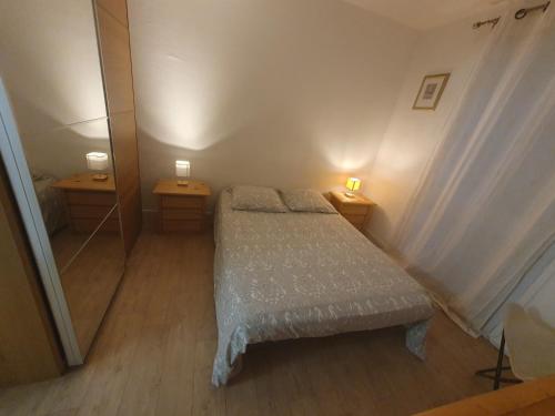 a small bedroom with a bed and two night stands at Le lilas d orly in Orly