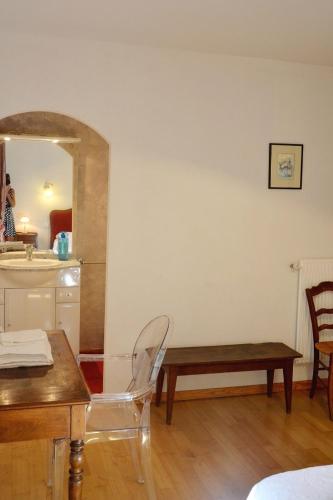 a room with a table and a bench and a mirror at Chambre dhôtes au pigeonnier in Poulan-Pouzols