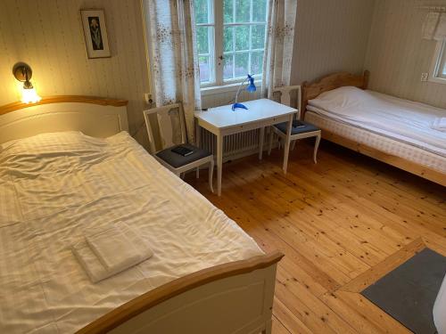a bedroom with a bed and a desk and a bed and a table at Trunnagården in Orsa
