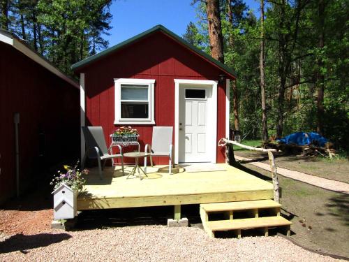 a red and white shed with a porch and a bench at Grizzly Gulch Cabin Historic in Keystone