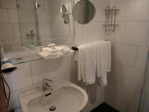 ein Badezimmer mit einem Waschbecken, einem Spiegel und Handtüchern in der Unterkunft Haus Zervreila in Vals