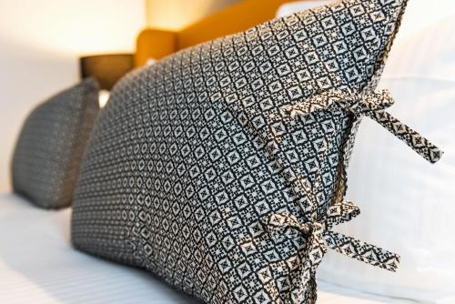 a pillow with a bow on it on a bed at Ténéo Apparthotel Talence Espeleta - Bordeaux Sud in Talence