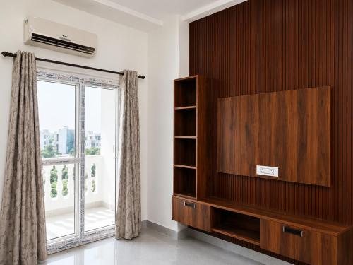 a living room with a tv and a window at Thecrestoria in Dehradun