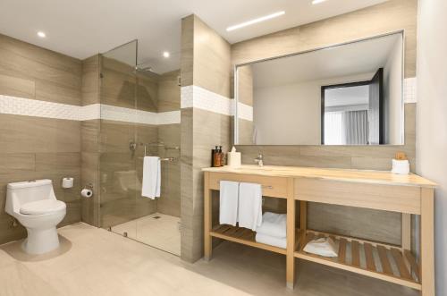 a bathroom with a shower and a toilet and a sink at Fiesta Inn Mérida Altabrisa in Mérida