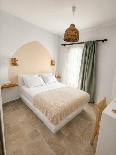 a bedroom with a white bed and a window at Villa Sofia Traditional Cycladic living in Kampos Paros