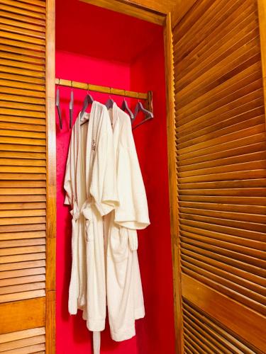 a closet with white clothes hanging on a rack at Las Guacamayas Lodge, Selva Lacandona, Chiapas México in Tlatizapán